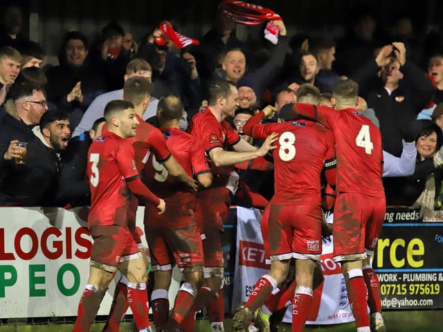 Harrison Neal is mobbed by his team-mates after making it 3-1
