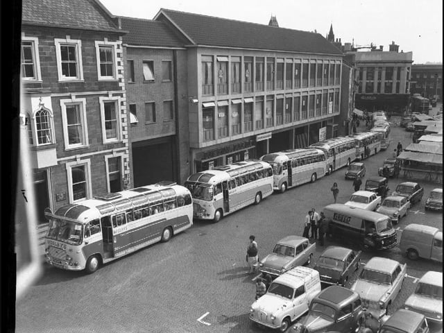 At least eight Wesleys coaches gather on Northampton Market Square to take passengers on an outing. Outside the Peacock Way arcade....September 10, 1964