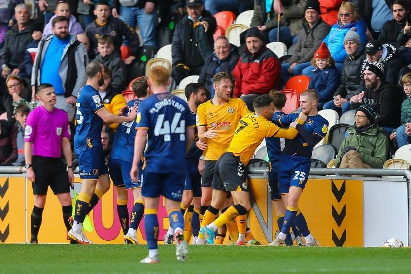 Newport County midfielder Robbie Willmott pushes Mansfield Town midfielder Ryan Stirk before John-Joe O'Toole is set off in the melee.