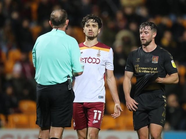 Referee Carl Boyeson shows Jack Sowerby of Northampton Town and Alex Gilliead of Bradford City a yellow card.
Photo: Getty Images