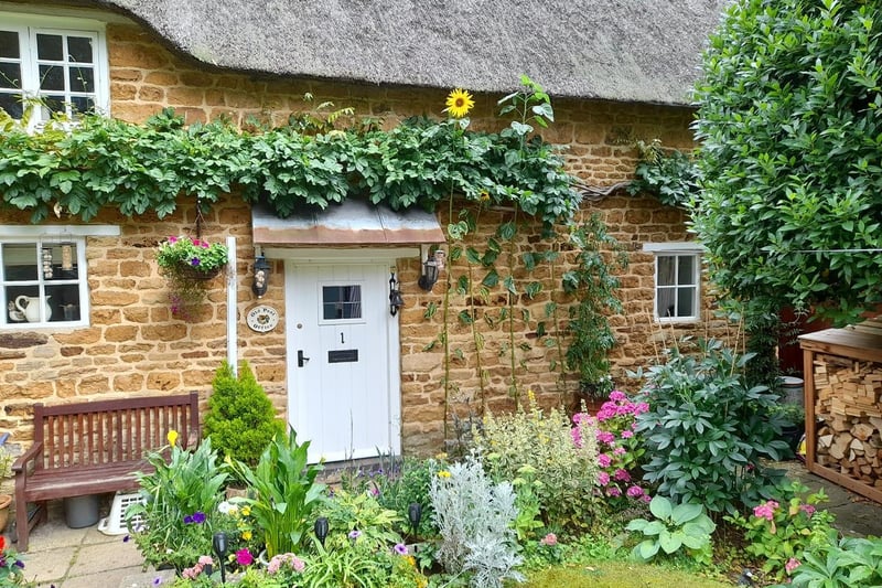 Stunning tall sunflowers standing guard outside this quaint looking cottage. Photo: Ian Warren