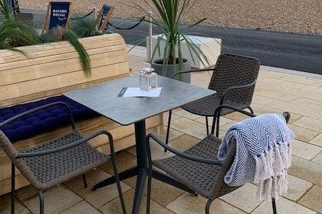 Cushioned benches and comfy chairs with blankets make up the outdoor seating area at Bayside Socail on Worthing seafront