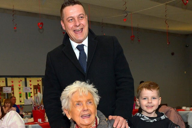 Helen Hume, from Carnhill, who celebrated her 82nd birthday at the DEEDS ‘Love-in-a-bucket’ Dementia Valentines Tea-Dance in Caw community Centre on Wednesday morning wearing the mayoral chain pictured with Mayor Alderman Graham Warke and his son Ollie. Photo: George Sweeney.  DER2207GS – 004