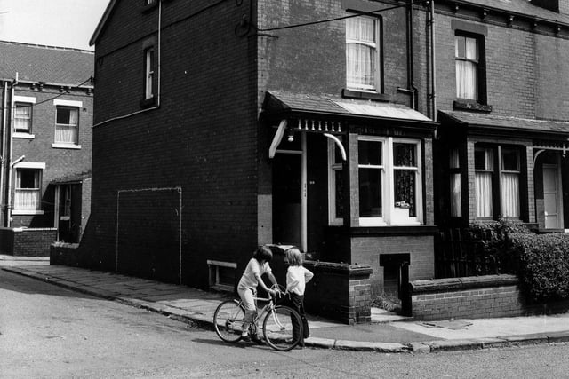 Burlington Road from the junction with Harlech Avenue in July 1975. Back Burlington Road is on the left with the rear of no. 180 Tempest Road visible. Two children are seen in the foreground, one of them on a bicycle.