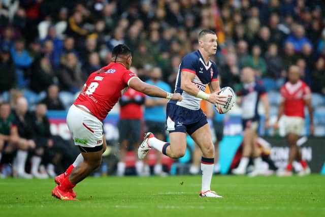 Harry Newman on the attack for England in last week's Test at Huddersfield as Tonga's Silvia Havili closes in. Picture by Jess Hornby/Getty Images.