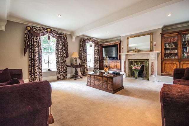 This stunning sitting room has a brass fireplace, and leads through to the orangery.