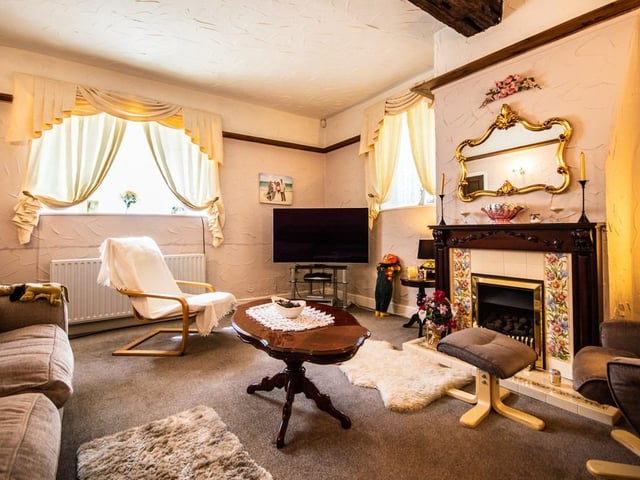 An alternative view of this room with decorative fireplace and windows overlooking the grounds.