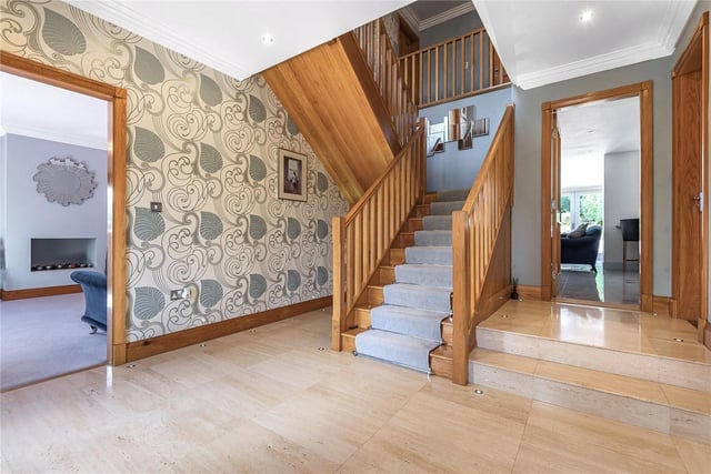 On the ground floor is a large, welcoming reception hall with a solid oak return staircase, leading to the first-floor accommodation. There's a storage cupboard below, attractive tiled flooring with underfloor heating, inset floor lighting and access to a guest WC.