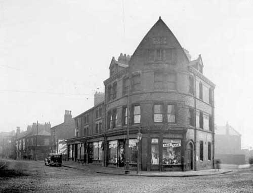 Marsh Lane in February 1934. The junction with East Street is to the right. Numbers 2-6 Marsh Lane, premises of Barnett Gould, gentlemans' outfitter, shop has 'sale' notices in windows. The junction to the left is with Garland Fold. On the corner of East Street, business of Hirst Brothers.