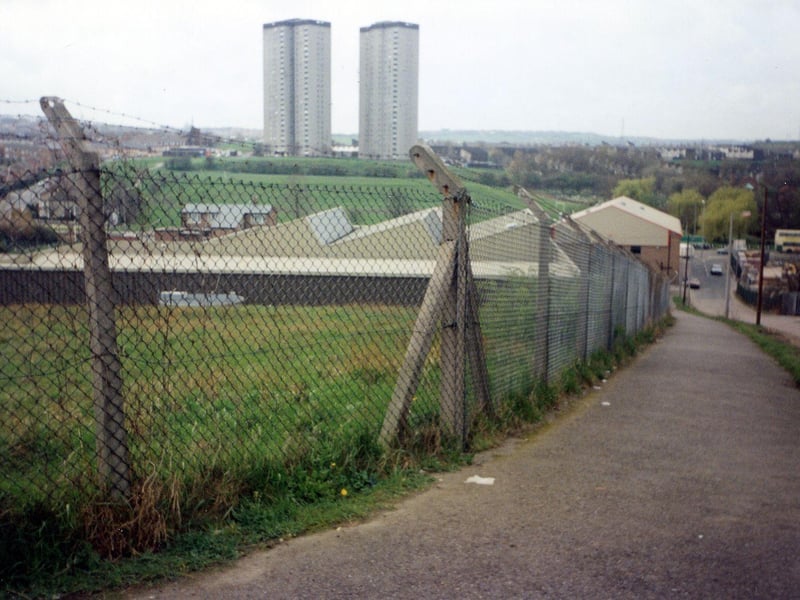 Beeston's Crow Nest Lane on the right, pictured in December 1990. Industrial works can be seen in the centre with the tower blocks of Cottingley Towers and Cottingley Heights in the background.