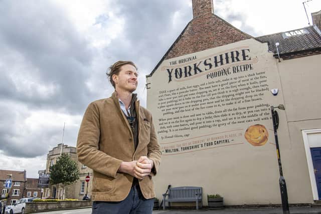 Tom Naylor-Leyland, organiser of the Malton Food Festival, in front of the large mural of a Yorkshire pudding recipe dating from the 18th century which was created a couple of years ago on the side of Insurance brokers McClarrons