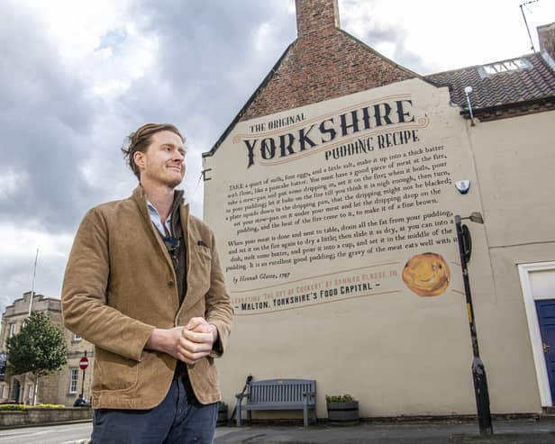 Tom Naylor-Leyland,  organiser of the Malton Food Festival, in front of the large mural of a Yorkshire pudding recipe dating from the 18th century which was created a couple of years ago on the side of  Insurance brokers McClarrons
