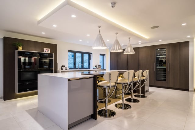 The bespoke kitchen with dining room has a four metre island, and a range of integrated Miele appliances, with Lutron controlled blinds, a Stucco and Stucco polished plaster feature wall and a mounted LED television.