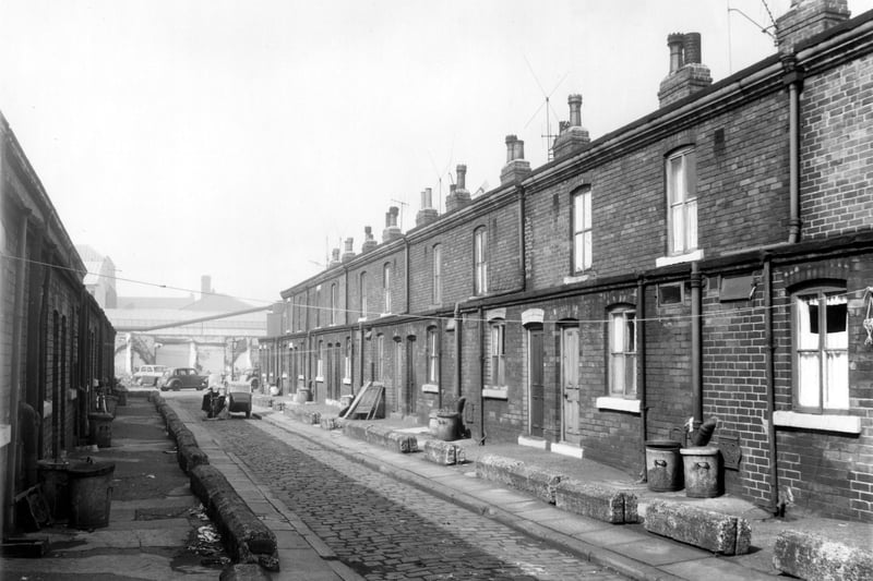 Looking down Hazelhead Place towards Albury Road. The backs of the houses on the left front on to Albury Terrace and the houses on the right open their front doors on to Clarence Road. Hazelhead Place is cobbled and a motorbike and sidecar is parked in the middle of the street.