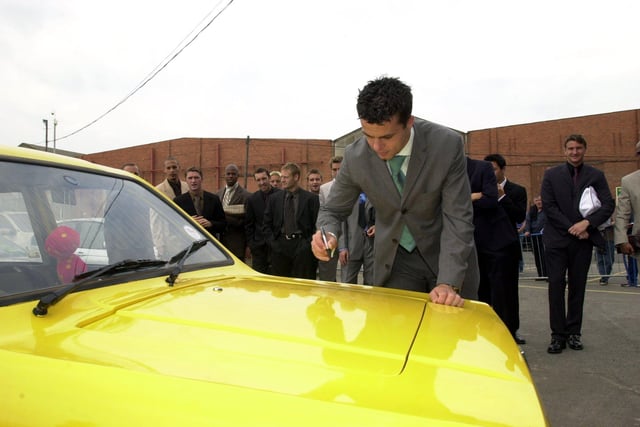 Ian Harte autographs the yellow Robin Reliant he drove to Elland Road after being voted the week's worst player in training by his teammates in August 2001.
