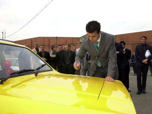 Ian Harte autographs the yellow Robin Reliant he drove to Elland Road after being voted the week's worst player in training by his teammates in August 2001.