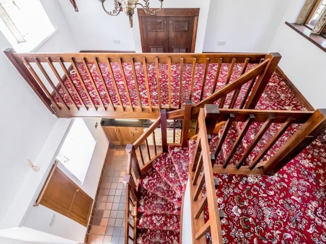 Looking down over the carpeted staircase to the hallway below.