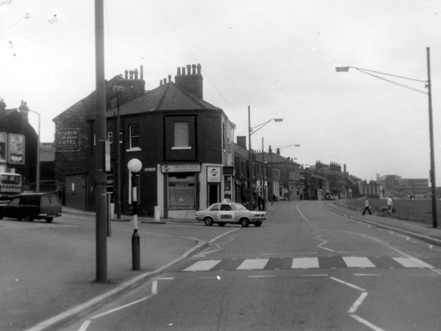 Looking east along Burley Road with the junction with Hyde Park Road to the left. On the corner is Smith's Cafe at no.134 Burley Road. Behind this can be seen the side of Andrew Commercial Hotel at no.130. A police car is turning the corner and there is a zebra crossing in the foreground. Pictured in August 1975.
