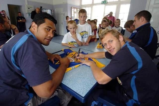 Ali Lauitiiti, left and Leeds Rhinos teammate Rob Burrow autograph a shirt in 2006. Picture by Tony Johnson.