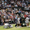 The Wimbledon crowd stand and applaud at the end of a game as Switzerland's Roger Federer and Serbia's Novak Djokovic take their seats during the men's singles final on day in 2019. (Pic: Getty Images)