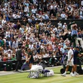The Wimbledon crowd stand and applaud at the end of a game as Switzerland's Roger Federer and Serbia's Novak Djokovic take their seats during the men's singles final on day in 2019. (Pic: Getty Images)