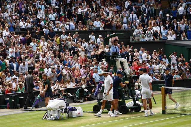 The Wimbledon crowd stand and applaud at the end of a game as Switzerland's Roger Federer and Serbia's Novak Djokovic take their seats during the men's singles final on day in 2019. (Pic: Getty Images)