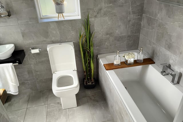 There is a modern fully tiled bathroom with multi-zone lighting, a bath, toilet and wash hand basin, plus dark solid wood shelving with access onto the rear decking.