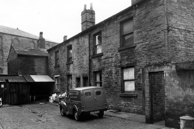 Stone built properties situated in the cobbled Hobson's Yard off Upper Town Street, and numbering from left to right, 10 to 4. Dustbins and cardboard boxes are piled up outside number 8. A van is parked on the cobbled yard with the name Abbotts (Caterers) Ltd. of 210 Town Street, Bramley, painted on the side. 'Weddings and Parties catered for'. Pictured in March 1960.