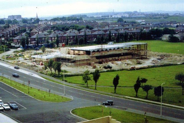 Queensway showing building in progress on the Scatcherd Sports Centre, later to become Morley leisure Centre in June 1973. In the foreground is the Entrance to the car park for Morrisons supermarket. In the background are houses on Corporation Street and Wynyard Drive.