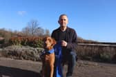 Paul Holden holding his Support Dogs running vest, alongside trainee support dog Rowlings