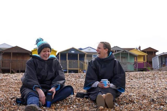 Two friends, wearing coats, have a conversation