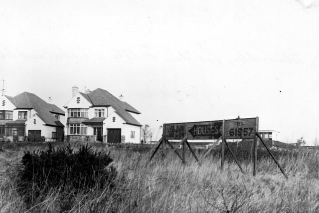 Two newly-built detached houses on Lakeland Crescent in February 1952. The view is taken from the plot that would become no. 61 Alwoodley Lane, where a billboard advertising the new houses encourages people to "live in the country."