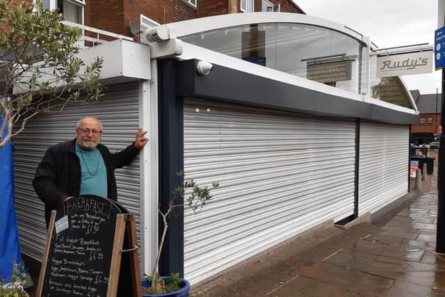 Owner of the Mad Greek, Kostas Tsiknakis, says that the shutters erected by Rudy's are costing him business