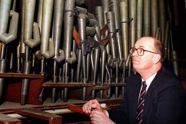 Organist and master of music Simon Lindley is pictured with a section of organ yet to be restored at Leeds Parish Church.