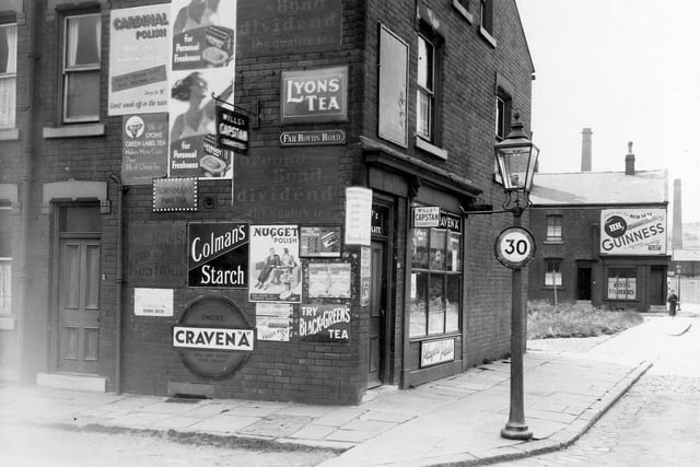 Shop on corner of Far Royds Road and Royds Lane in July 1939 . Adverts on wall for Cardinal Polish, Lyons Green Label Tea, Horniman's Pure Tea, Coleman's Mustard, Lifebouy Soap, Nugget Polish, Craven 'A' etc. To the right of picture, in the distance, can be seen Royd's Fisheries, with an advert for Guinness above. On the corner is a street lamp with a 30mph sign attached.