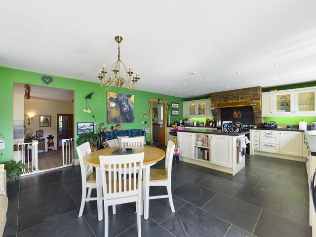 The large kitchen with diner and relaxed seating area has a central island unit, and bi-fold doors out to the gardens.
