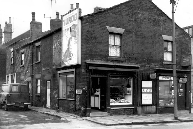 Seamer Street at the junction with Armley Road in February 1964. Fronting onto Armley Road are two shops which appears to be a butchers and adjacent, grocers.