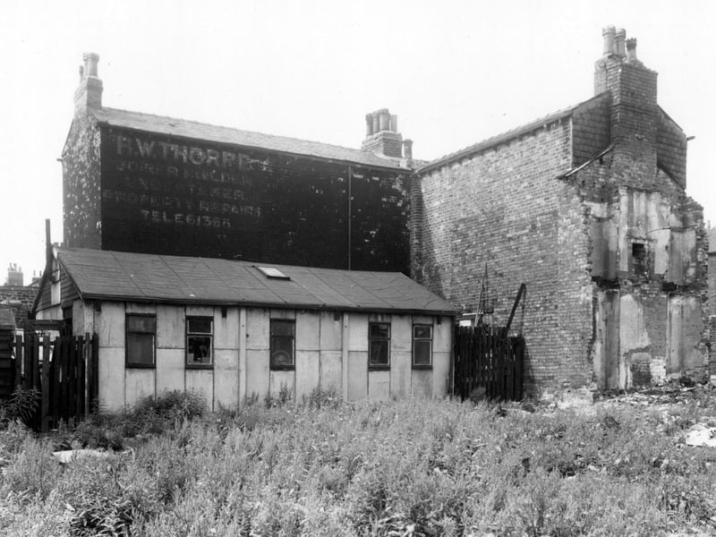 An area of waste ground, looking towards the rear of 1/3 Coleridge Street, which is to the left and 24/26 Arthur Street on the right in June 1960. A faded sign on the wall advertised H.W. Thorpe, joiner and builder. This was looking from Stoney Rock Lane.