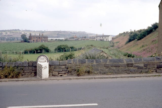 A milestone located near the bottom of Churwell Hill, Elland Road pictured in July 1968.  On the left hand side it reads Morley, 1 and a half miles, Birstall, 4 miles, Cleckheaton, 6 and a half miles and Brighouse, 10 miles. On the right hand side the distance to Leeds is given as 3 miles.