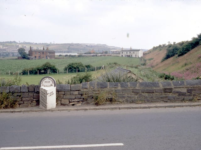 A milestone located near the bottom of Churwell Hill, Elland Road pictured in July 1968.  On the left hand side it reads Morley, 1 and a half miles, Birstall, 4 miles, Cleckheaton, 6 and a half miles and Brighouse, 10 miles. On the right hand side the distance to Leeds is given as 3 miles.