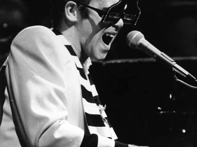 "He blazed untiringly through a string of rousing rockers reaching a peak on 'Bennie and the Jets' and a spanking version of Lucy in the Sky' and attacked the piano with honky tonk relish."