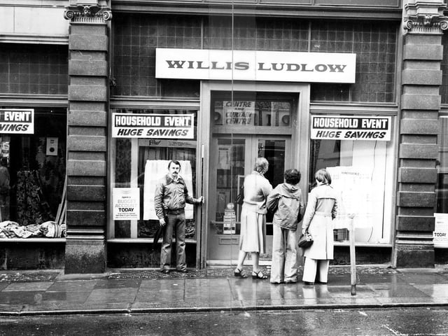Shoppers look in the windows which advertise a 'household event' promising huge savings.