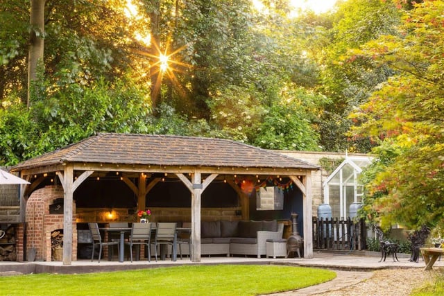 The timber framed gazebo and barbecue area which comes with a clay pizza oven .