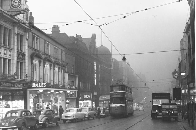 Trams trundle along Briggate in February 1957.