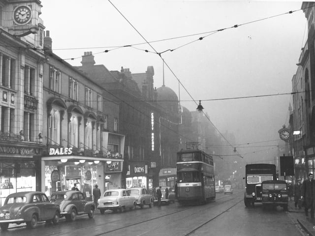 Trams trundle along Briggate in February 1957.