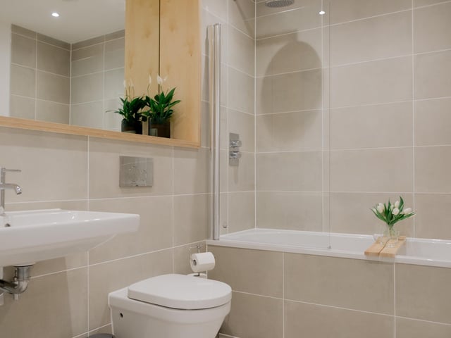 The bathroom suite includes a bath with shower overhead.