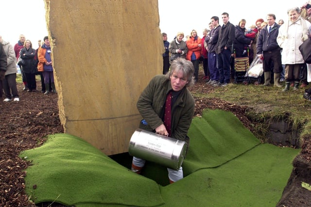 Glen Gorner, from Leeds Services Parks Department, lowers the time capsule into the hole ready for the covering on the edge of the Millennium Wood at Temple Newsam, Leeds in 2000.