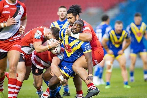 Samy Kibula, then of Warrington, is tackled by Salford's Pauli Pauli during a Super League match in 2020. Picture by Isabel Pearce/SWpix.com.