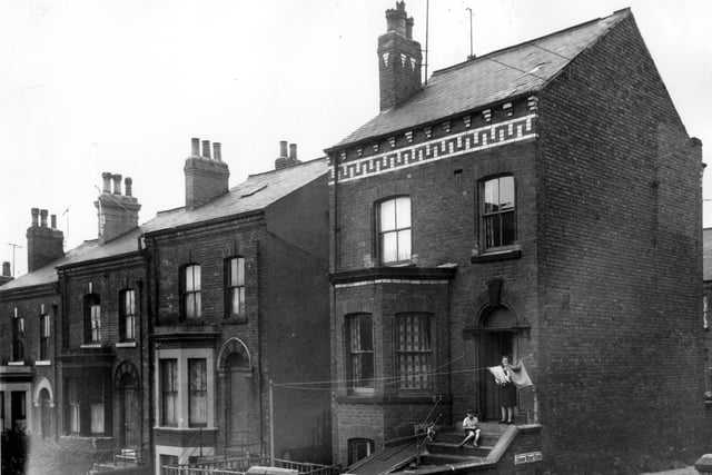 A lady stands at the door of a property on  West View, at junction with Cross West View, while a boy and the cat pose for the camera on the steps. Just seen to the right is Cross West View. Pictured in July 1964