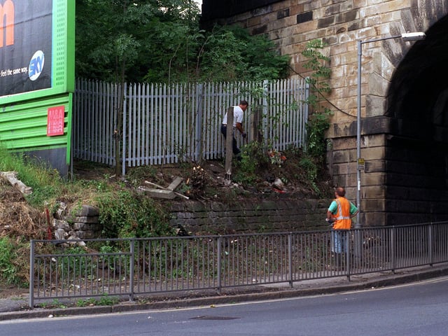 Workmen put up a fence and clear trees near to a railway bridge crossing the A63 Whitkirk-Selby Road stopping youngsters who have been seen throwing stones from the bridge at cars. Pictured in August 1997.